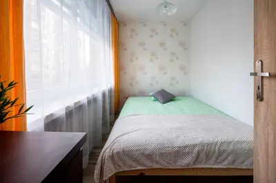 a small bedroom with a bed and a window at Like home in Kraków