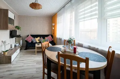 a kitchen and living room with a table and chairs at Like home in Kraków