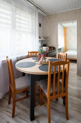a dining room table with chairs and a kitchen at Like home in Kraków
