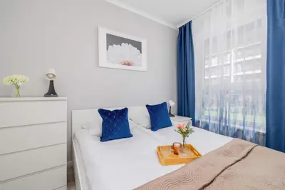 a bedroom with a bed with a tray of flowers on it at Cozy Apartment with Parking and Terrace in Kraków by Noclegi Renters in Kraków