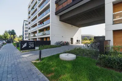 a building with a fountain in the grass in front of it at Cozy Apartment with Parking and Terrace in Kraków by Noclegi Renters in Kraków