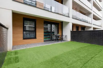 a house with a green lawn in front of it at Cozy Apartment with Parking and Terrace in Kraków by Noclegi Renters in Kraków