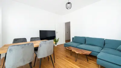 a living room with a blue couch and a table at Rakowicka Steam Park, Sun & Snow in Kraków