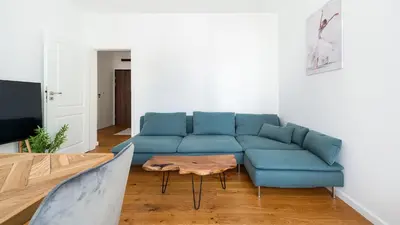 a living room with a blue couch and a table at Rakowicka Steam Park, Sun & Snow in Kraków