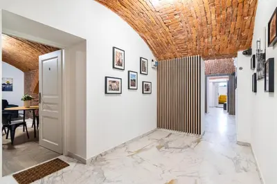 a hallway with white walls and a wooden ceiling at The Hidden Nook in Kraków