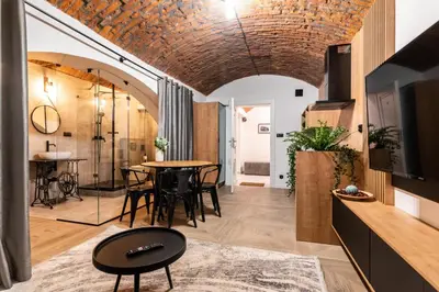 a room with a table and chairs and a television at The Hidden Nook in Kraków