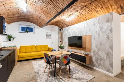a living room with a yellow couch and a table at The Hidden Nook in Kraków