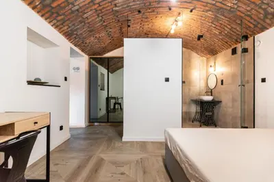a room with a bed and a desk and a mirror at The Hidden Nook in Kraków