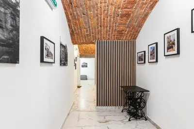 a hallway with a table and pictures on the walls at The Hidden Nook in Kraków