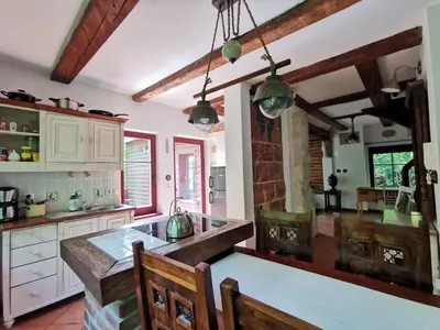 a kitchen with a table and chairs in a room at Domek Samotnia w ogrodzie in Kraków