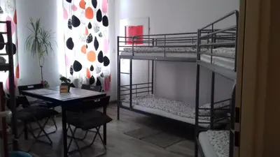 a room with two bunk beds and a table at ART Hostel in Kraków