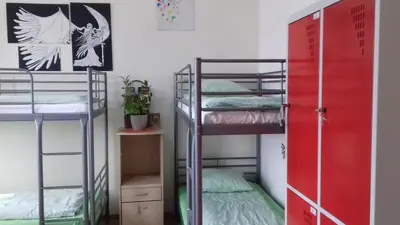 a room with three bunk beds and a red door at ART Hostel in Kraków
