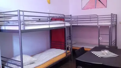 a room with two bunk beds and a table at ART Hostel in Kraków