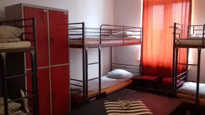a room with four bunk beds with a table at ART Hostel in Kraków