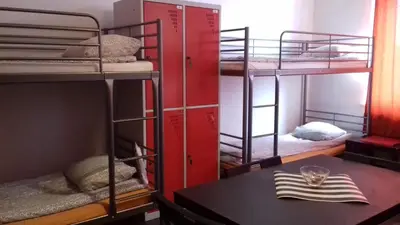 a room with three bunk beds and a table at ART Hostel in Kraków