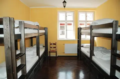 three bunk beds in a room with a window at The Little Havana Party Hostel in Kraków