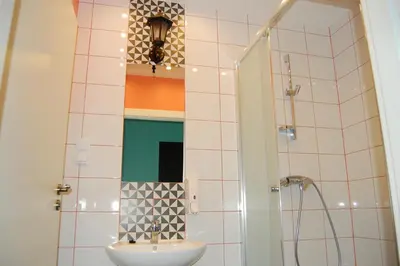 a bathroom with a sink and a shower at The Little Havana Party Hostel in Kraków