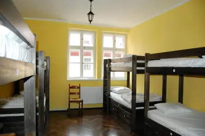 a room with four bunk beds and a window at The Little Havana Party Hostel in Kraków
