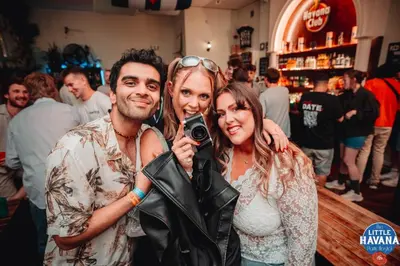 a group of people posing for a picture at a party at The Little Havana Party Hostel in Kraków