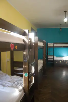 a room with three bunk beds in a room at The Little Havana Party Hostel in Kraków