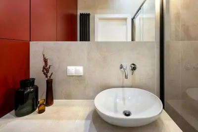 a bathroom with a white sink and a red wall at WLB Apartments in Kraków