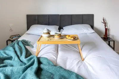 a table with a tray of food on a bed at WLB Apartments in Kraków