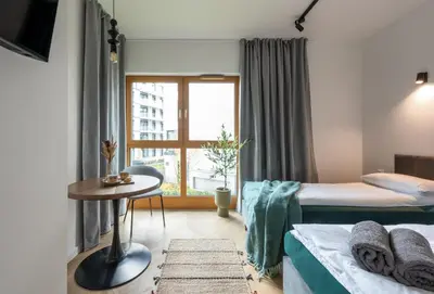 a small room with two beds and a window at WLB Apartments in Kraków