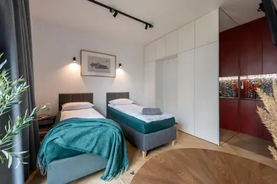 a bedroom with two beds and a table at WLB Apartments in Kraków