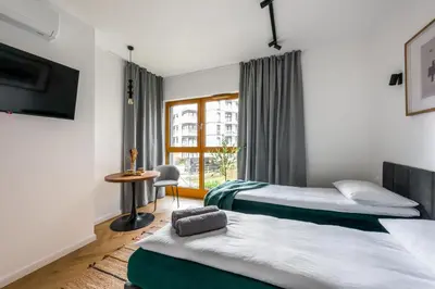 a hotel room with two beds and a window at WLB Apartments in Kraków