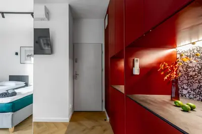 a red kitchen with a counter and a red wall at WLB Apartments in Kraków