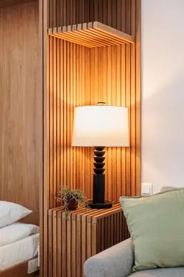 a lamp on a wooden wall next to a bed at Stylowe Studio - Nowy Kleparz - Kraków - by Upstairs in Kraków