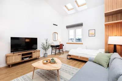 a living room with a couch and a tv at Stylowe Studio - Nowy Kleparz - Kraków - by Upstairs in Kraków