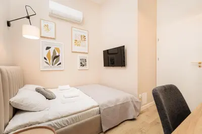 a bedroom with a bed and a tv on the wall at Felicjanek 15 - Central 3-Bedroom Apartment - by Upstairs in Kraków