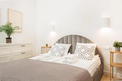 a white bedroom with a large bed with white pillows at Felicjanek 15 - Central 3-Bedroom Apartment - by Upstairs in Kraków