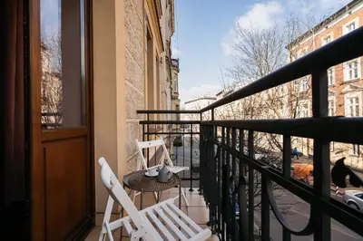 two chairs and a table on a balcony with a view at Native Apartments Brzozowa 15 in Kraków