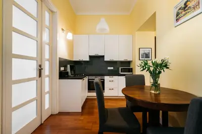 a kitchen with a table and a dining room at Native Apartments Brzozowa 15 in Kraków