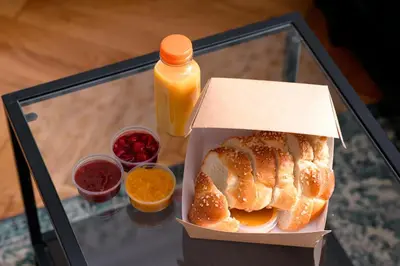 a box of bread and a bottle of orange juice at Native Apartments Brzozowa 15 in Kraków