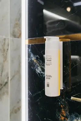 a bottle of sunscreen sitting on a counter in a bathroom at Native Apartments Brzozowa 15 in Kraków