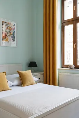 a white bed in a bedroom with a window at Native Apartments Brzozowa 15 in Kraków