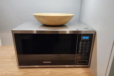 a microwave with a bowl on top of it at Grey Apartment Kraków in Kraków