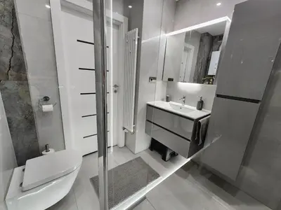 a bathroom with a toilet and a sink and a shower at Grey Apartment Kraków in Kraków