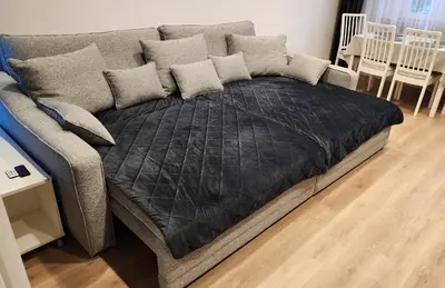 a bed with a black comforter and pillows on it at Grey Apartment Kraków in Kraków
