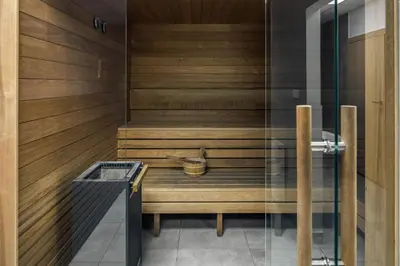 a sauna with wooden walls and a glass door at Iron Street by A11 Sauna in Kraków