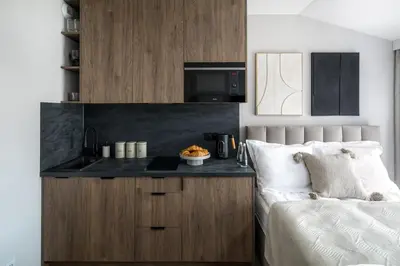 a bedroom with a bed and a counter with a microwave at Iron Street by A11 Sauna in Kraków
