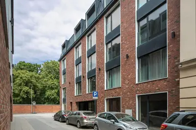 a brick building with cars parked in front of it at Iron Street by A11 Sauna in Kraków
