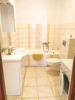 a bathroom with a sink and a toilet and a washing machine at Apartamenty Dolna Kraków in Kraków