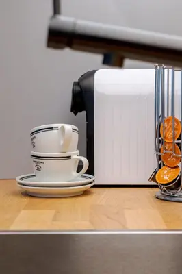 a coffee maker and a cup on a counter at Bright and cosy flat near the river in Kraków