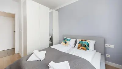 a bedroom with a large white bed with pillows at Przedwiośnie, Sun & Snow in Kraków