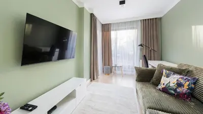 a living room with a couch and a flat screen tv at Przedwiośnie, Sun & Snow in Kraków