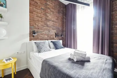 a bedroom with a bed and a brick wall at Cracow Fancy Brick #1 - Old Town in Kraków